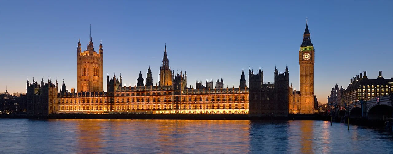 Palace of Westminster illuminated across the River Thames at dusk