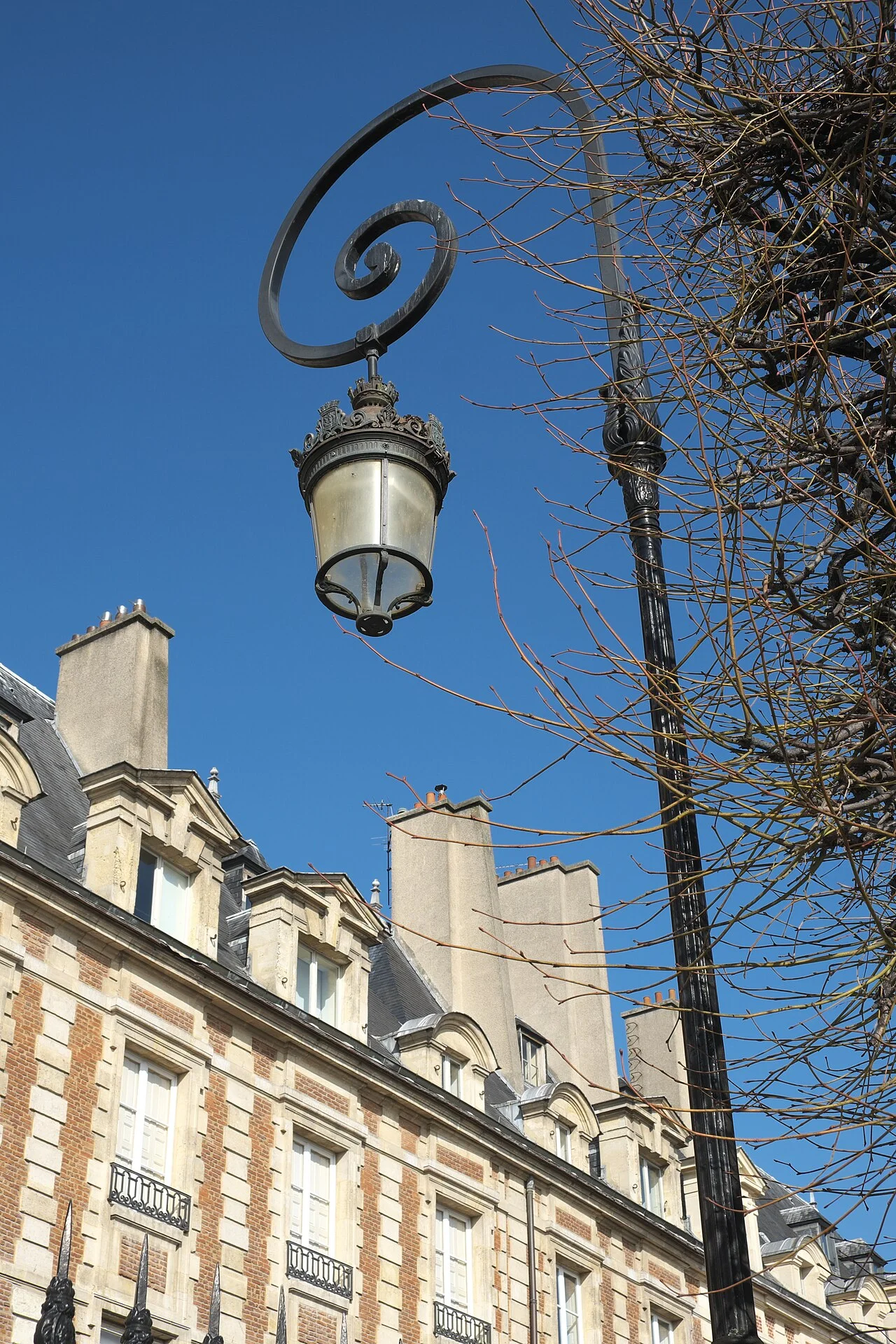 Historic facades and street lamp at Place des Vosges in the Marais